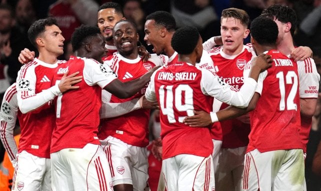 Arsenal players, including Myles Lewis-Skelly and Jurrien Timber, celebrate a goal against Kairat Almaty to seal their perfect record.