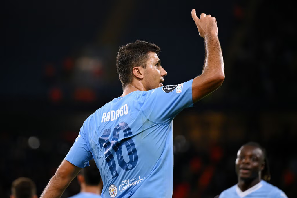 Rodri wearing number 16 jersey pointing upwards.